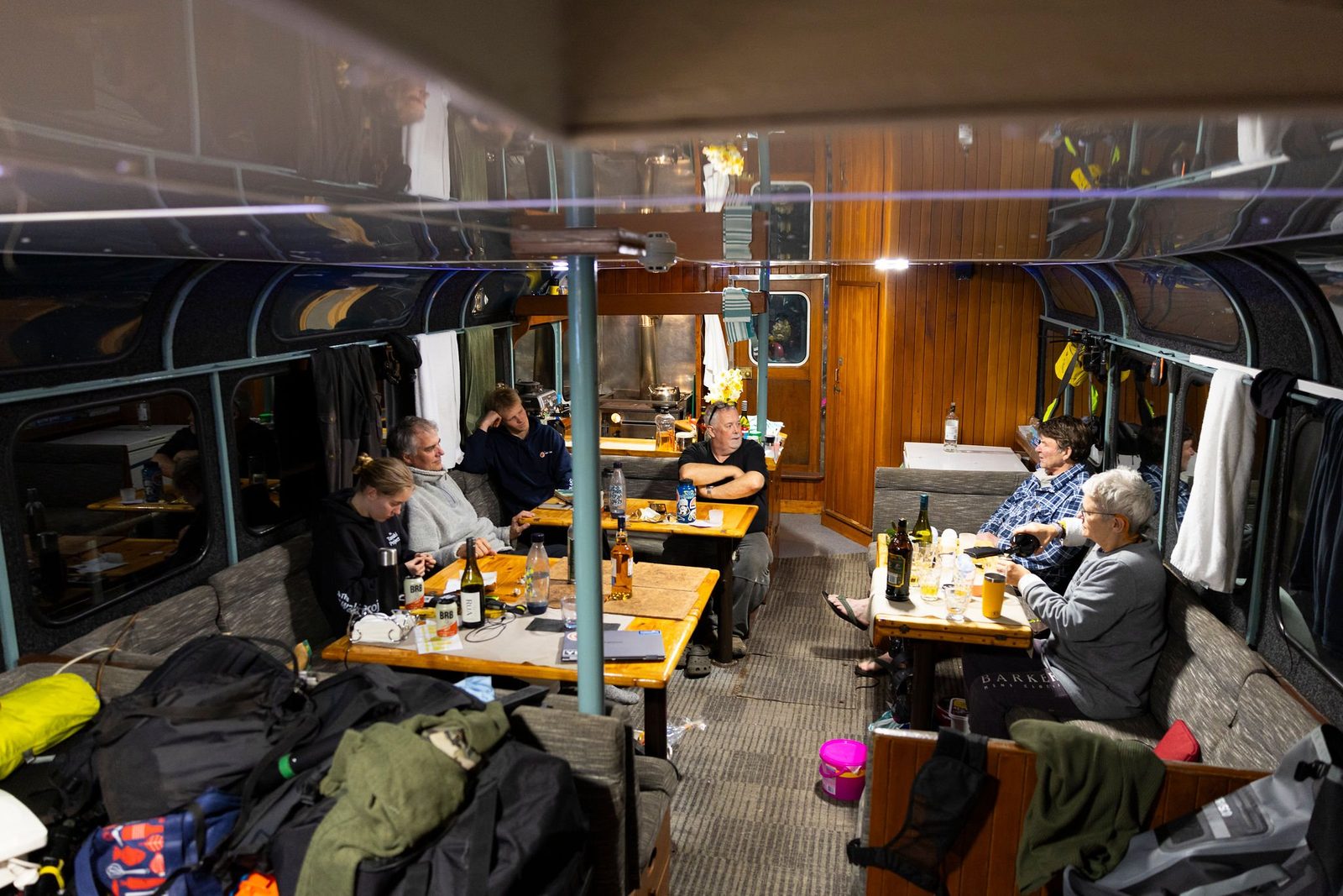 Guests around the tables in the saloon of MV Tutoko in the evening