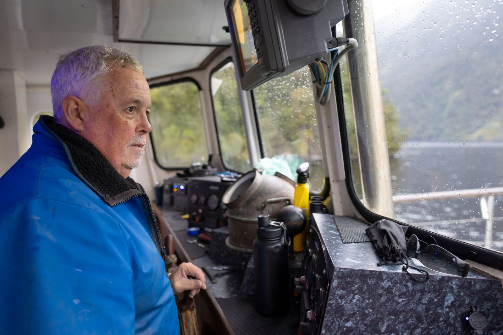 Skipper at the wheel in the wheelhouse of MV Tutoko